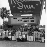 Holiday Inn Staff Posing in Front of Hotel Sign in Celebration of 9th Anniversary