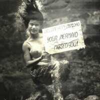 Weeki Wachee Mermaid Rita King Posing Underwater with a Welcome Home Sign for Her Parents